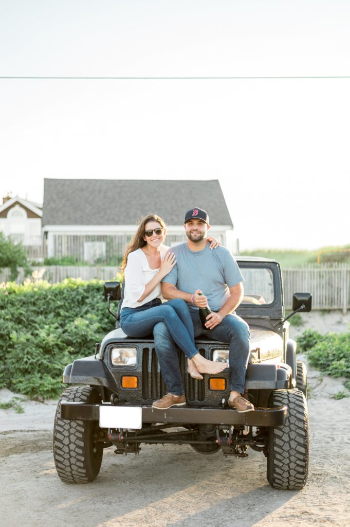Cape Cod couple on a jeep wrangler popping a bottle of champagne 