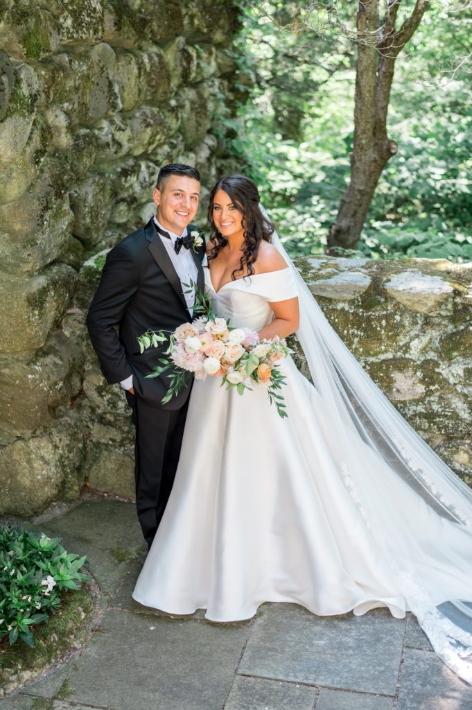 Bride and groom wedding portrait in the garden with beautiful stone walls 