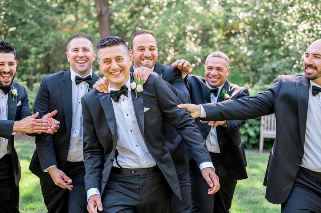 Summer outdoor wedding party portraits with groomsmen at The Connors Center