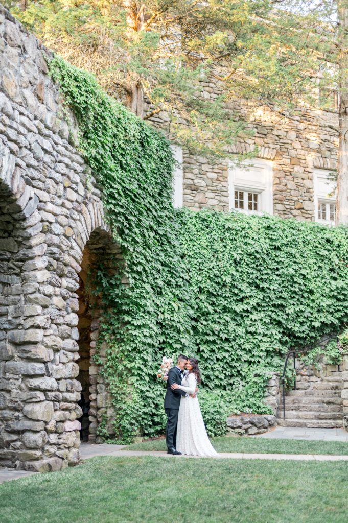 Bride and groom portraits against a stone wall at The Connors Center