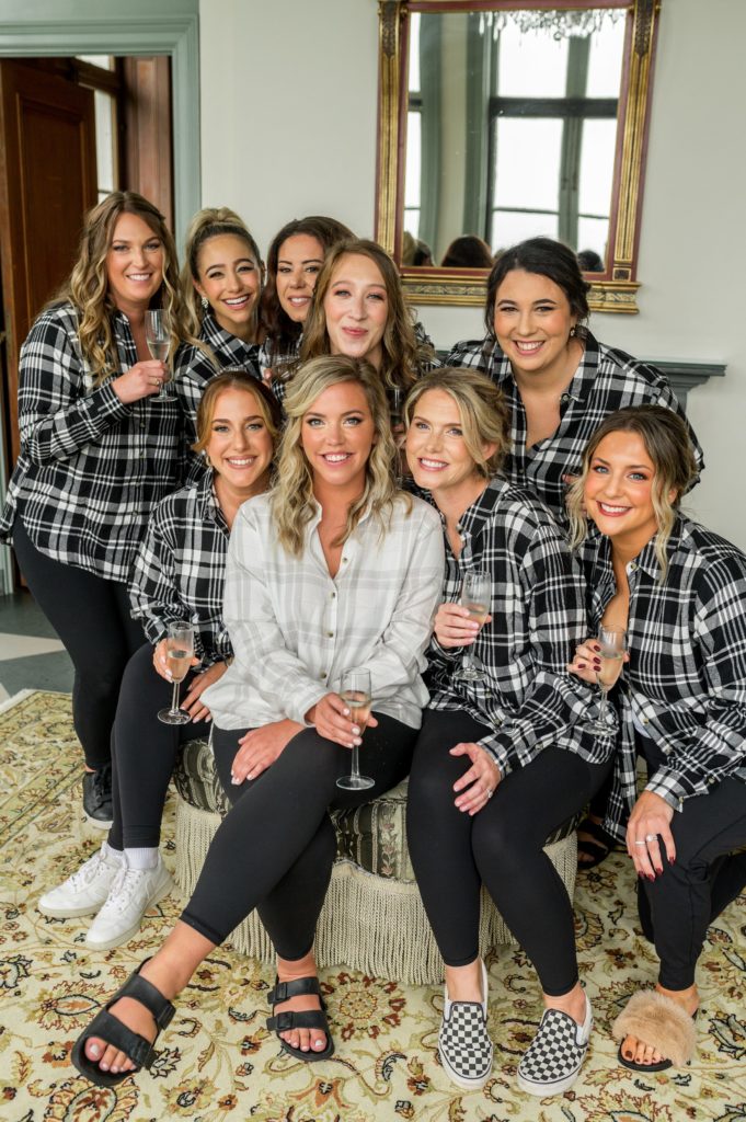 bride and bridesmaids wearing matching flannels while getting ready