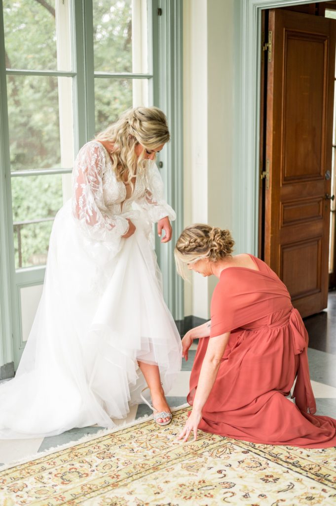 Bride getting help putting on her shoes 