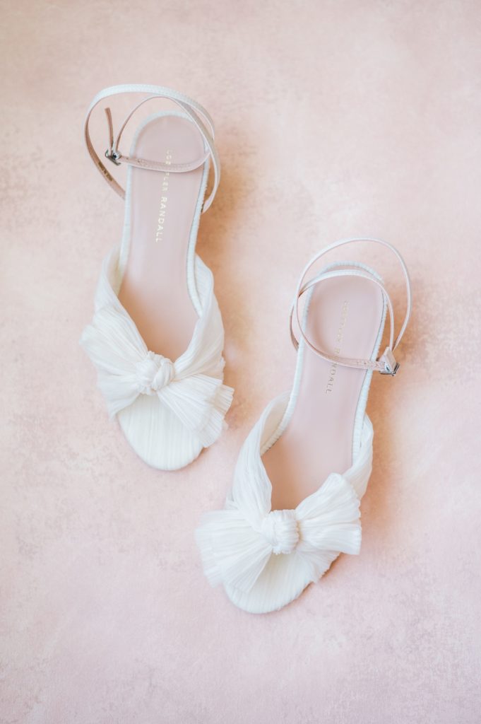 Detail photography of gorgeous wedding heels with pink backdrop 