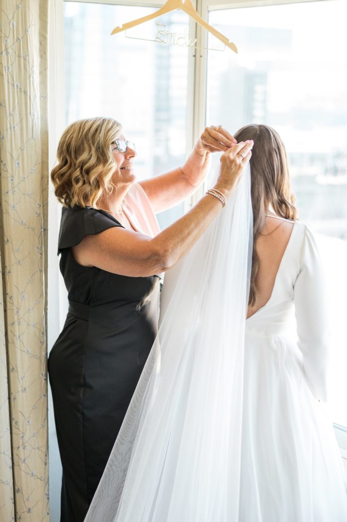 Mother of the bride putting on the bride's veil for Davio's Seaport Boston Fall Wedding