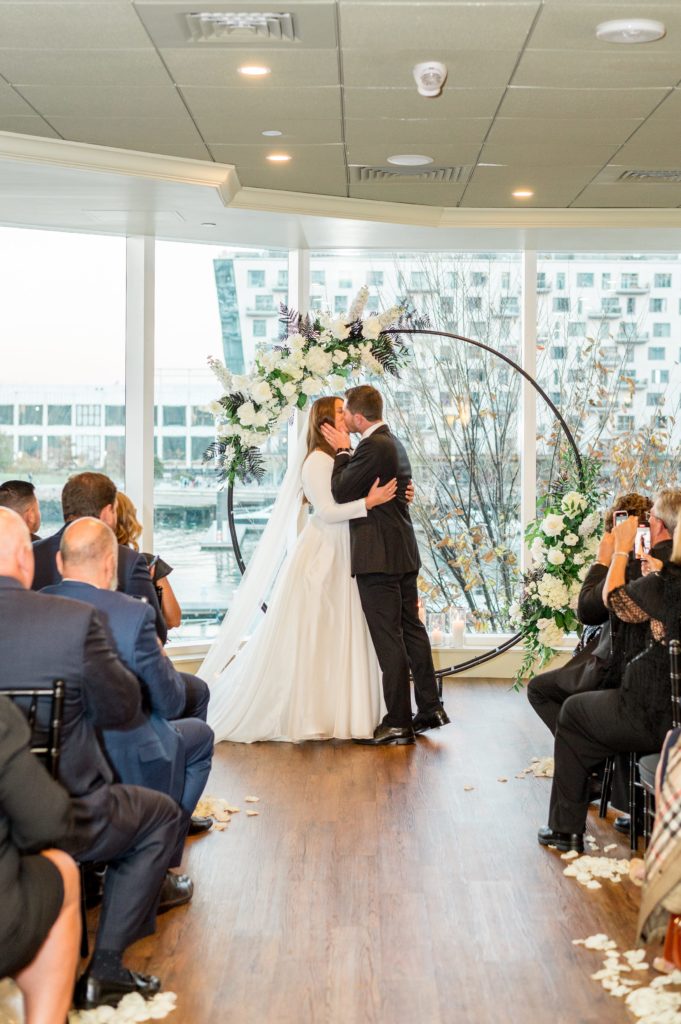 Bride and groom first kiss at Davio's Seaport Boston Fall Wedding