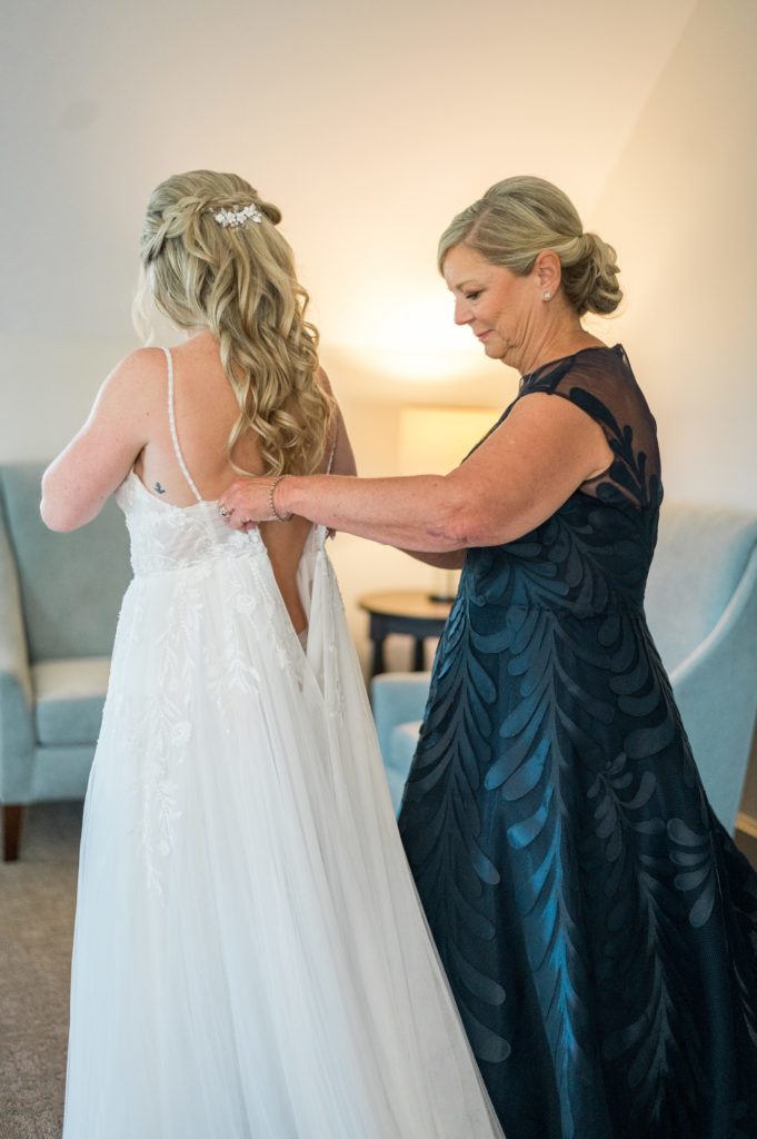 Mom helping her daughter put on her wedding gown for The Barn at Gibbet Hill Summer Wedding