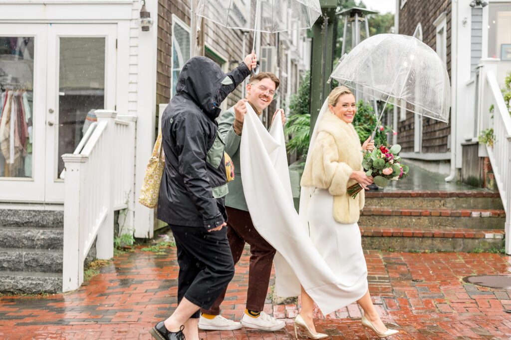 Rainy wedding day in Provincetown , bride walking to her wedding under umbrella 