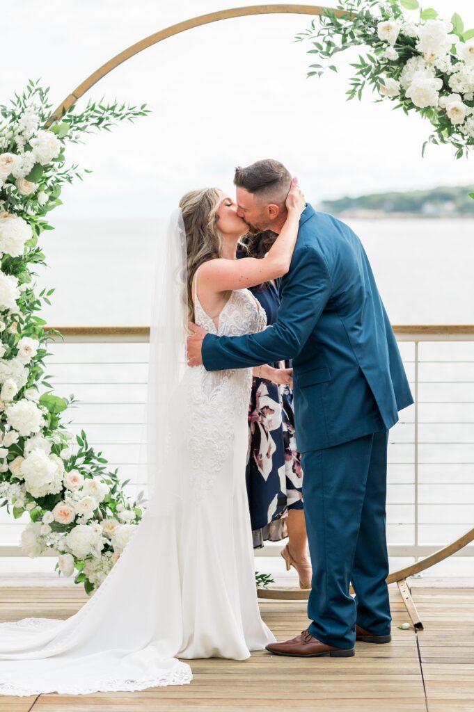 Bride and groom first kiss for outdoor ocean view wedding ceremony for North Shore wedding