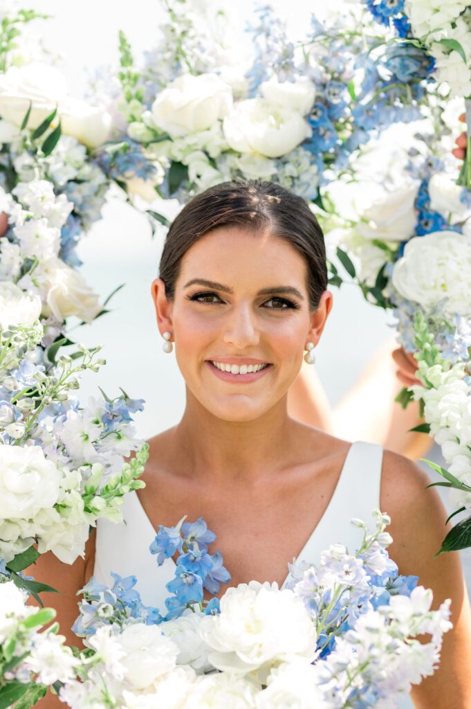 Up close bridal portrait surrounded by flowers for coastal wedding