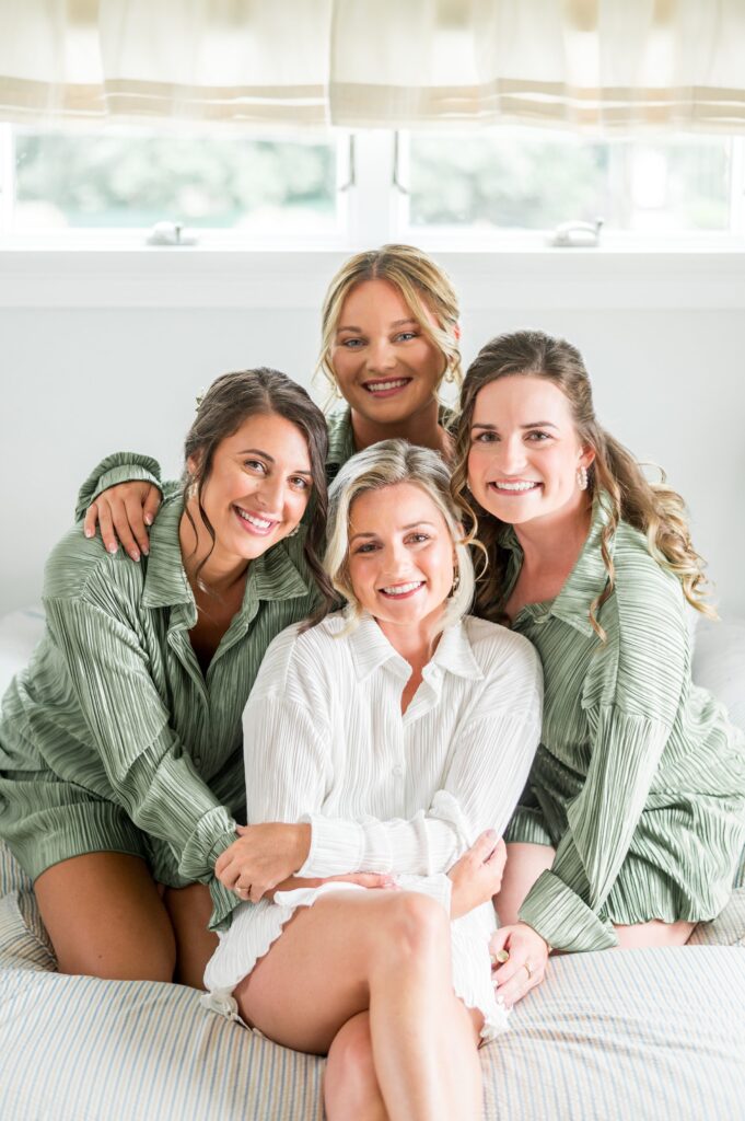 Bride and bridesmaids getting ready wearing matching PJs in sage green 