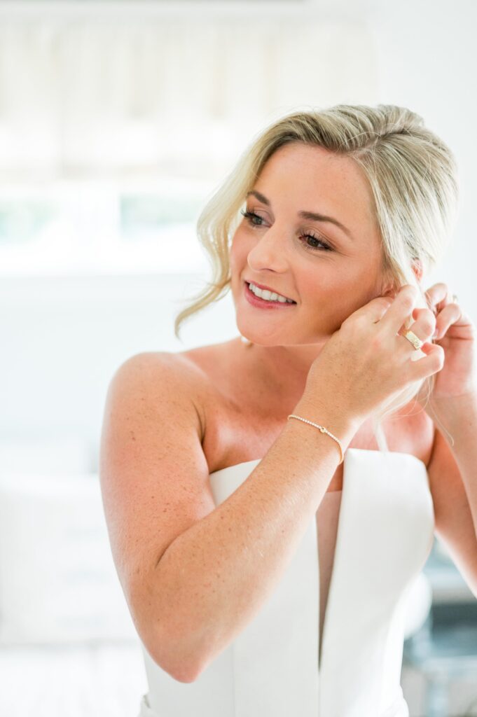 Bride putting on earrings, getting ready photography for Cape Cod tented wedding
