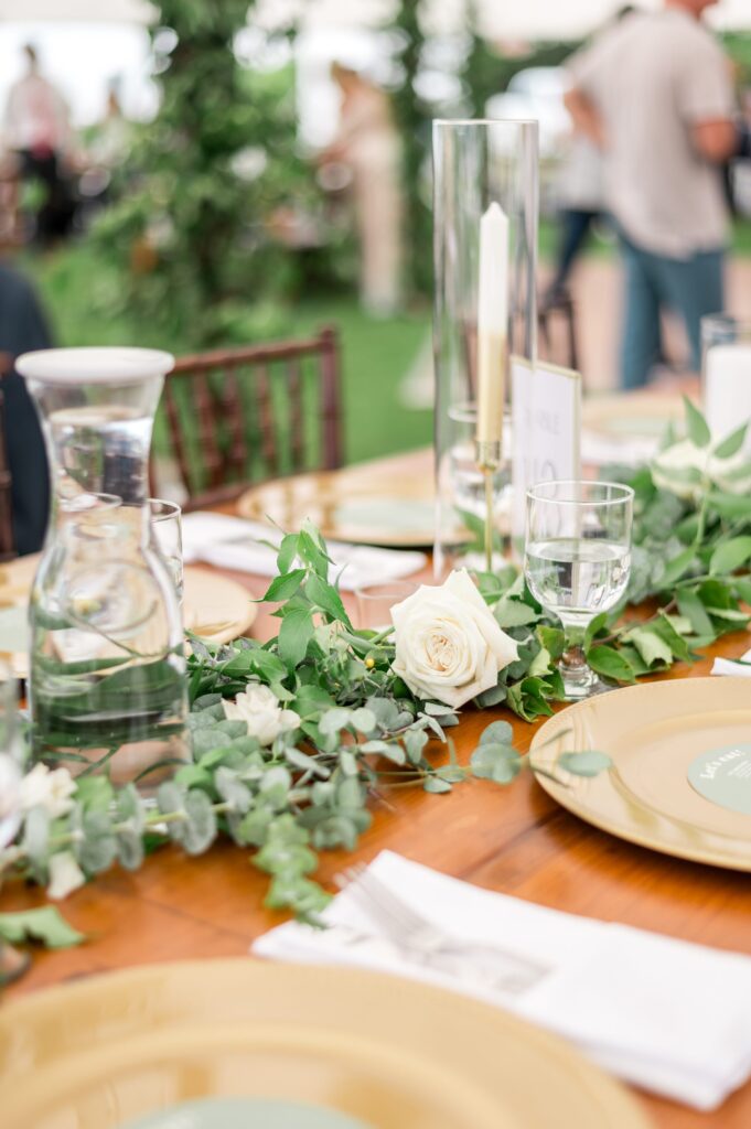 Cape Cod tented wedding table decor with greenery and single rose stems 