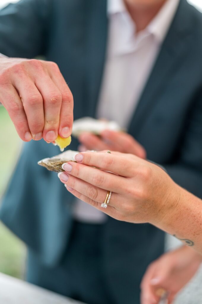 Bride and groom doing oyster shooters during wedding reception and detail shot of engagement ring and wedding band