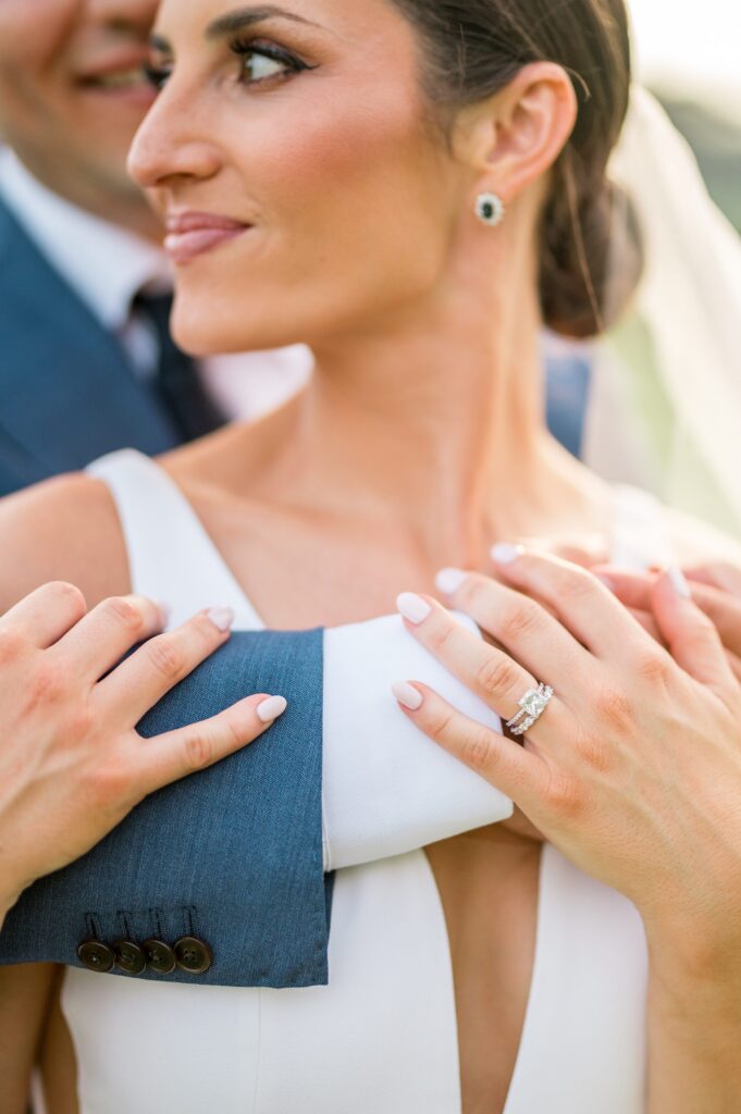 Close up photo of engagement ring and wedding bands on bride and groom at Farm Neck Golf Club Martha's Vineyard wedding