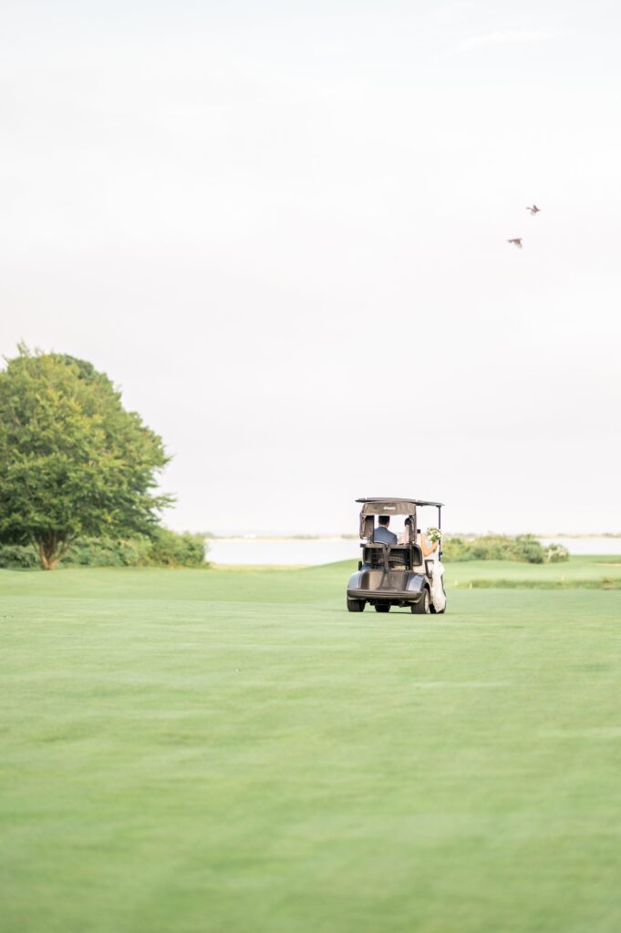 Bride and groom riding in golf cart at Farm Neck Golf Club
