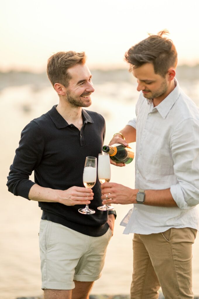 Couple popping Veuve champagne during engagement photos 