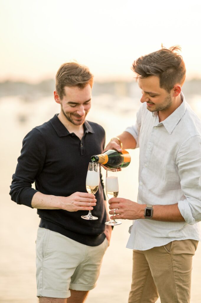 Couple popping Veuve champagne during engagement photos 