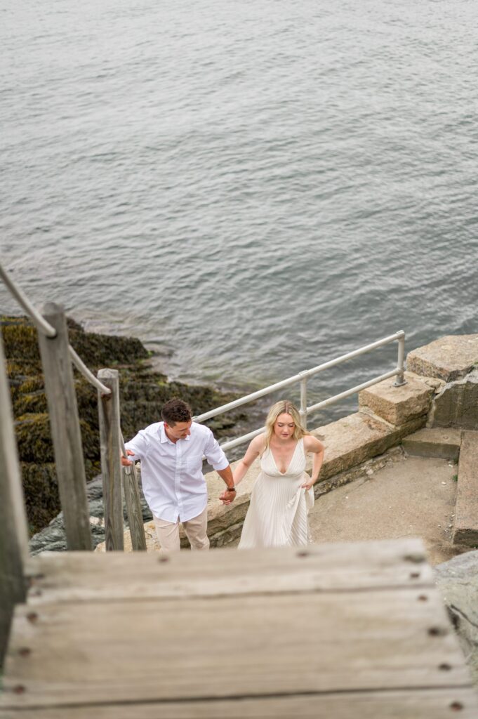 Couple holding hands and walking up the stairs at the Castle Hill Lighthouse