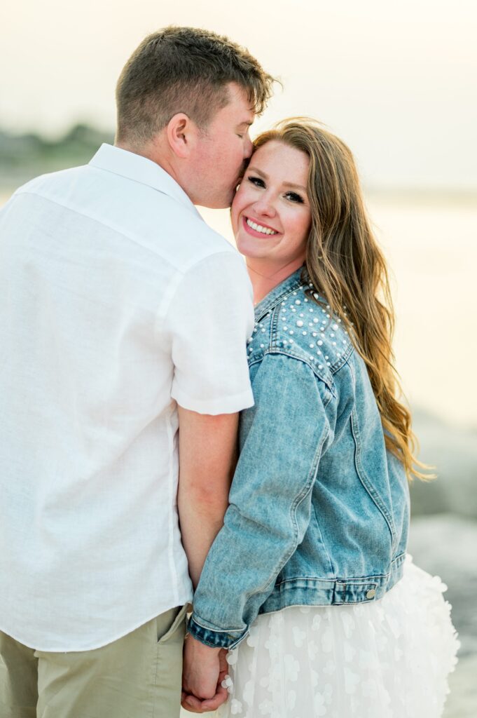 South Shore beach engagement photos wearing a jean jacket with pearl details 