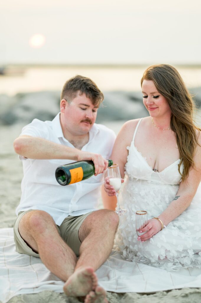Couple pouring Veuve champagne during engagement photos