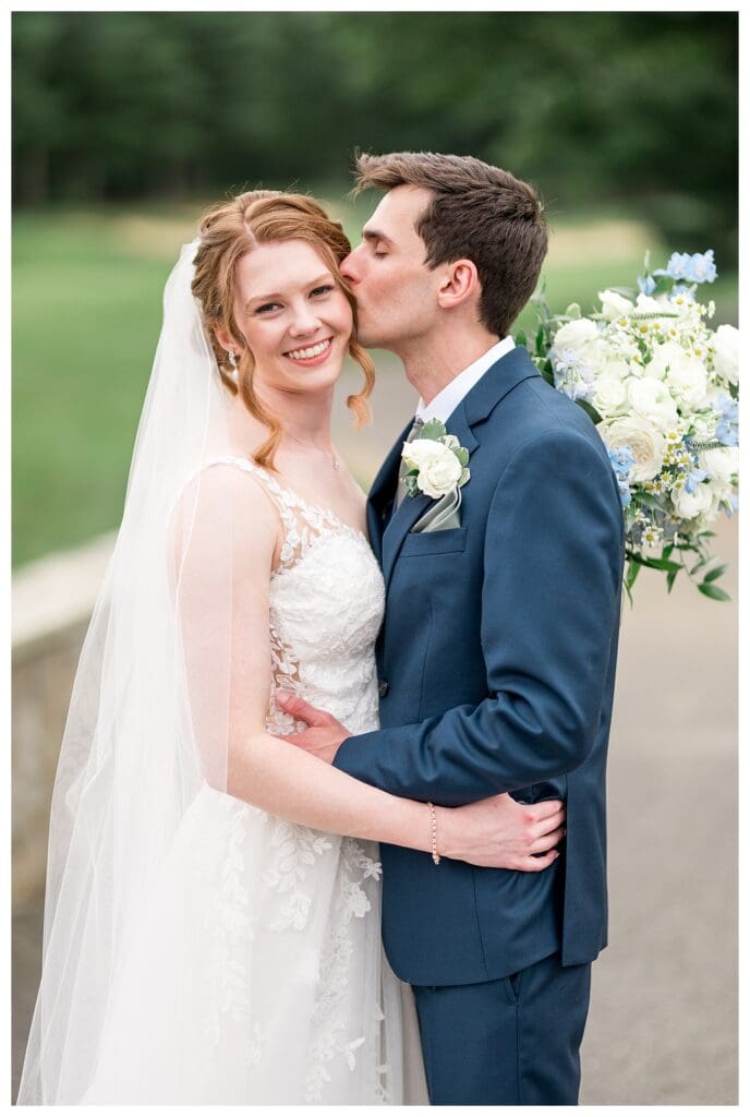 Bride and groom share a forehead kiss in a romantic quiet moment