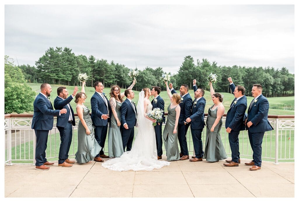 The full wedding party celebrates together on the porch at Indian Pond.
