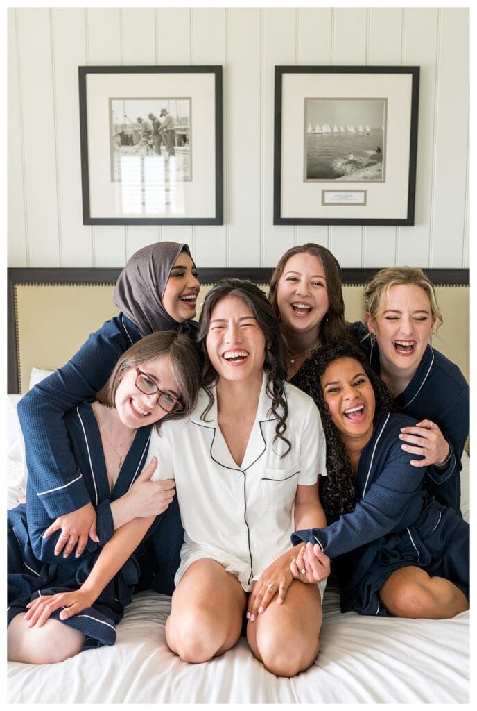Bride laughing with bridesmaids during candid getting-ready photos full of joy and natural light.
