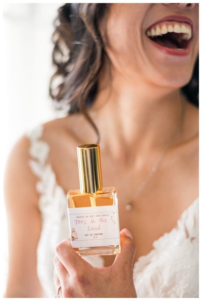 Close-up of bridal perfume bottle and jewelry styled for wedding day details photography.