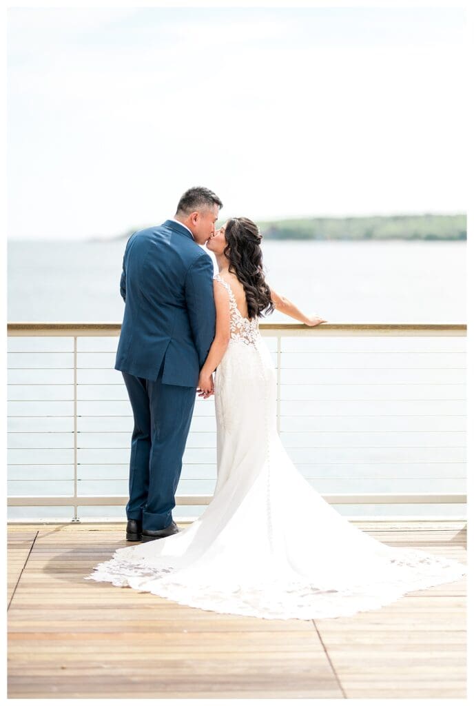 Bride and groom sharing a romantic portrait on the balcony of The Beauport Hotel overlooking the harbor.