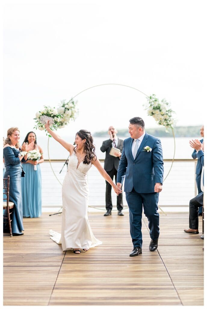 Newlyweds walking hand in hand down the aisle at The Beauport Hotel.