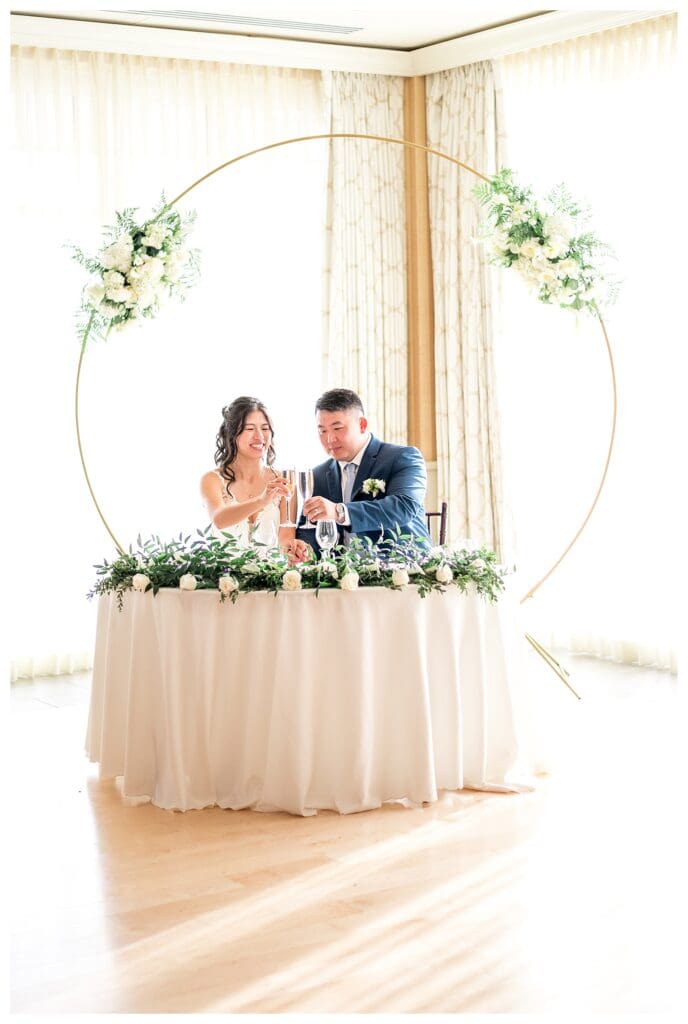 Wedding reception tables styled with candles, white florals, and elegant coastal decor.
