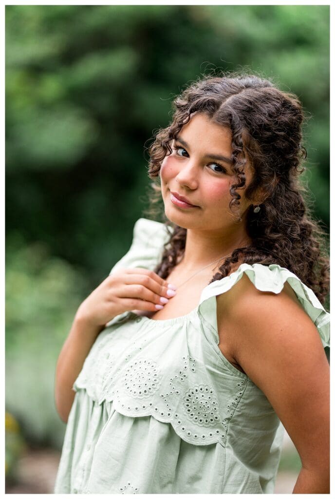Natural outdoor senior portrait, smiling confidently at the camera.