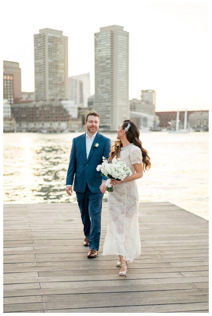 Couple holding hands with the city skyline in the background.