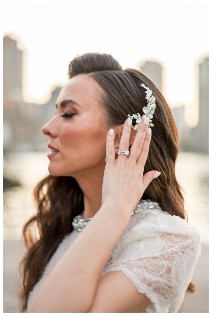 Bride adjusting her hairpiece during a quiet moment.