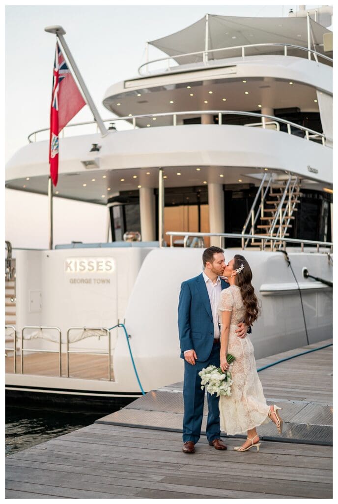 Newlyweds Kissing in front of a yacht called "Kisses" in the Boston Seaport.