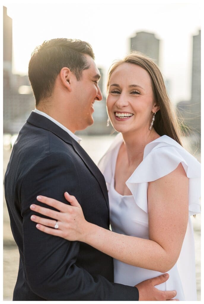 Bride-to-be smiling while her fiancé looks at her lovingly.