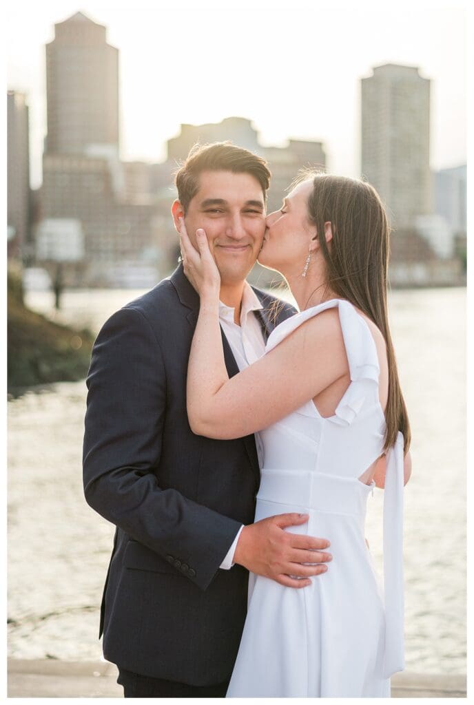 Sweet cheek kiss in front of the water.