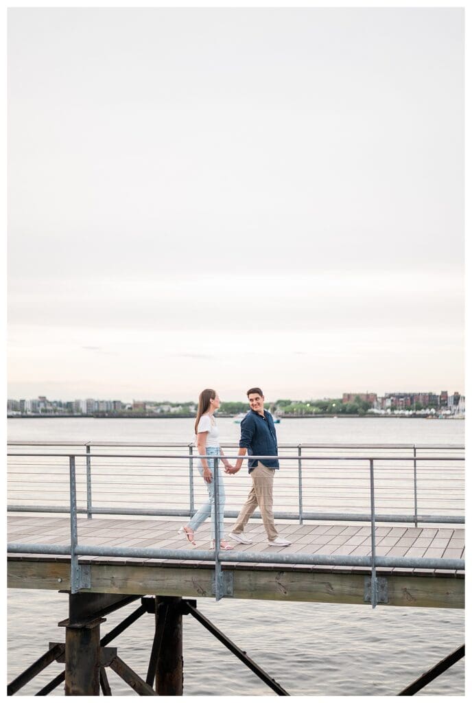 Couple walking along the Harborwalk holding hands.