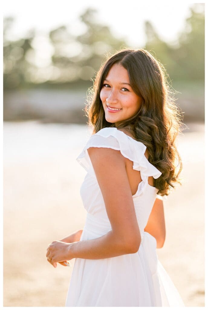 Senior girl laughing during her beach portraits.