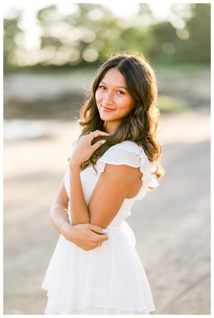 Senior portrait of Izzy at Lynch Park beach during golden hour.