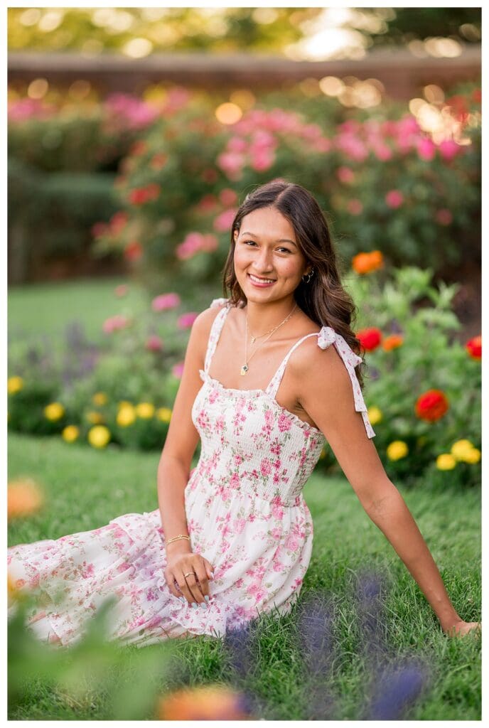 Senior portrait in a rose garden at golden hour.