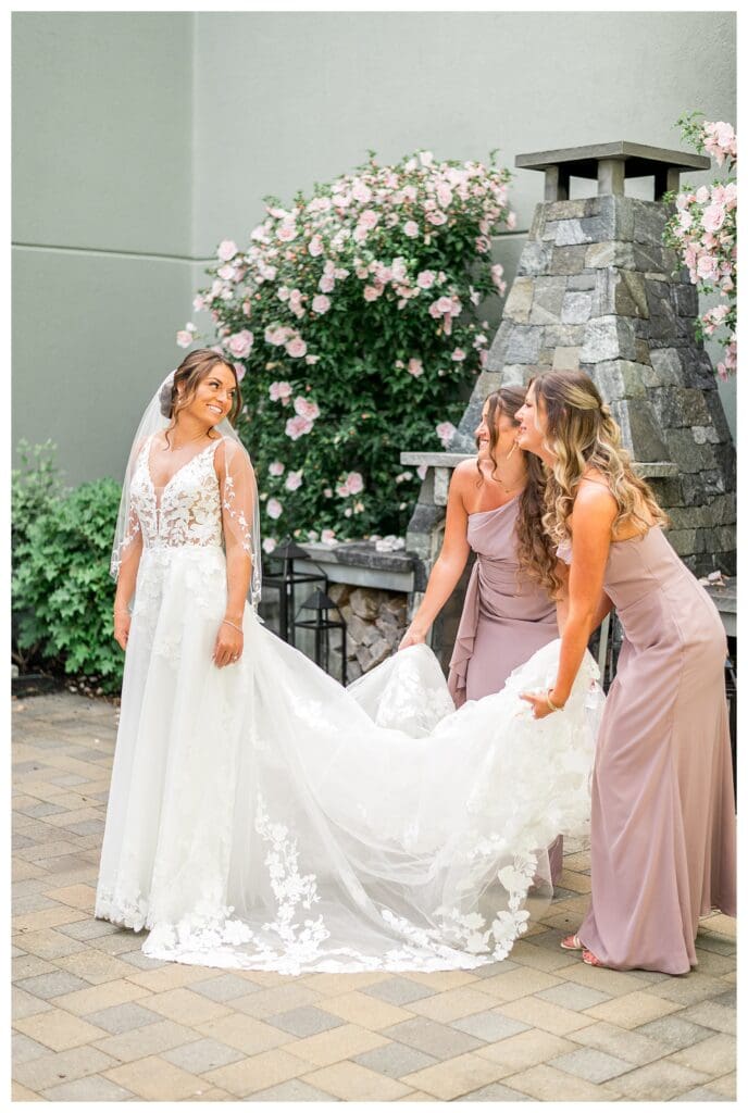 Bride and bridesmaids laughing together outside before portraits.