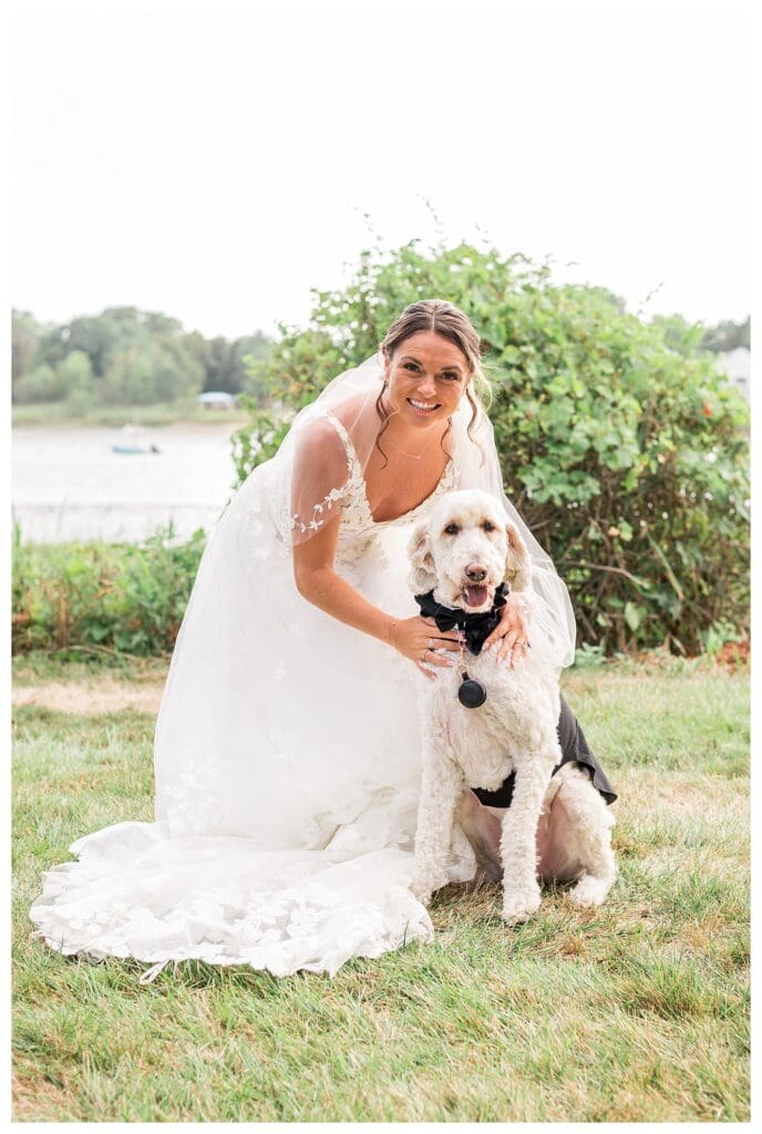 Noelle Lamber posing with her dog, Ollie at Danversport Yacht Club on her wedding day.
