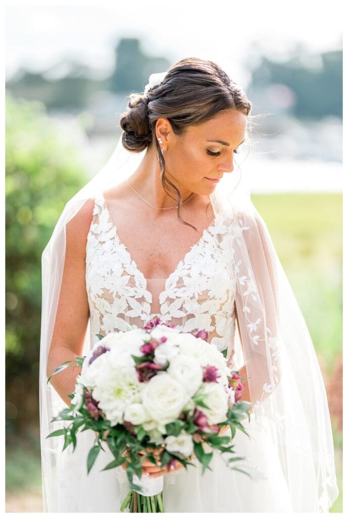 Bride holding bouquet with soft lilac and cream florals.