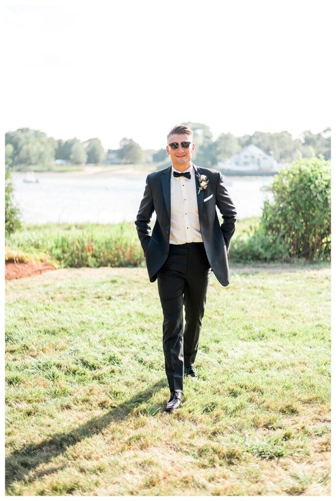 Groom walking confidently through the field for portraits.