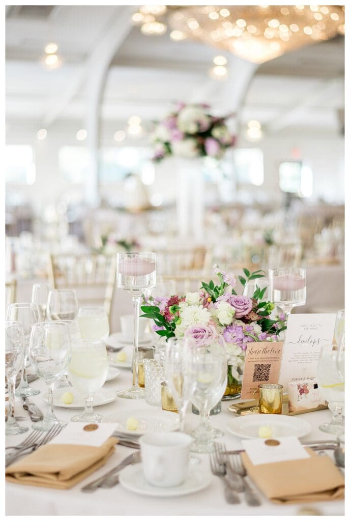 Reception table décor with soft purple and cream floral centerpieces.