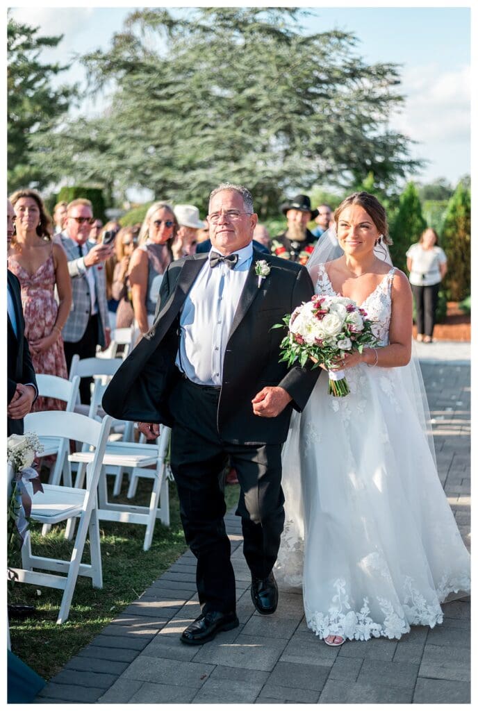 Bride and father walking down the ceremony aisle.
