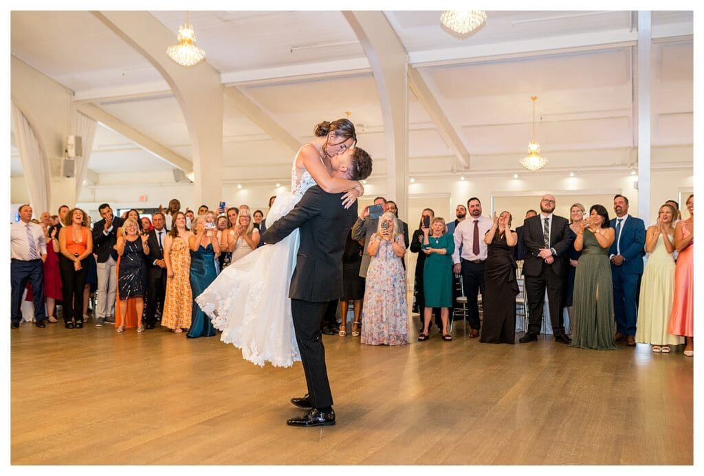 Groom lifting the bride on the dance floor.