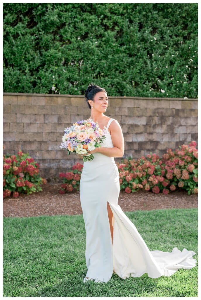 Bride holding pastel bouquet in ocean breeze at Wychmere.