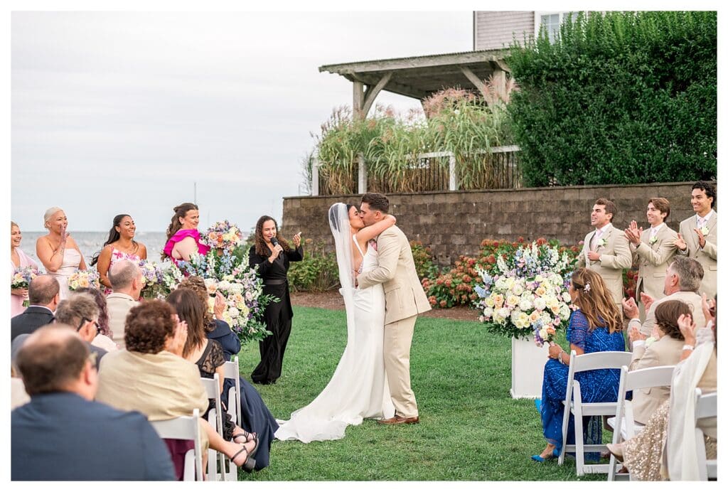 Bride & groom kissing on Wychmere’s waterfront ceremony lawn.